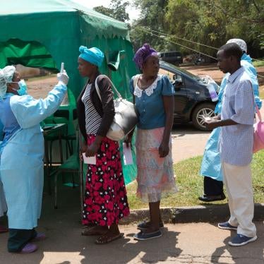 Health workers screen people visiting a public hospital in Harare, Zimbabwe, March 21, 2020.