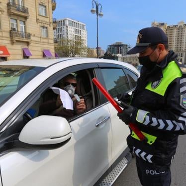A policeman verifies a driver's permission to be moving around the city in April 2020. 