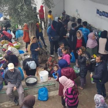 People in the Moria refugee camp on the Greek island of Lesbos wait to use one of the few overcrowded water stations in the camp.