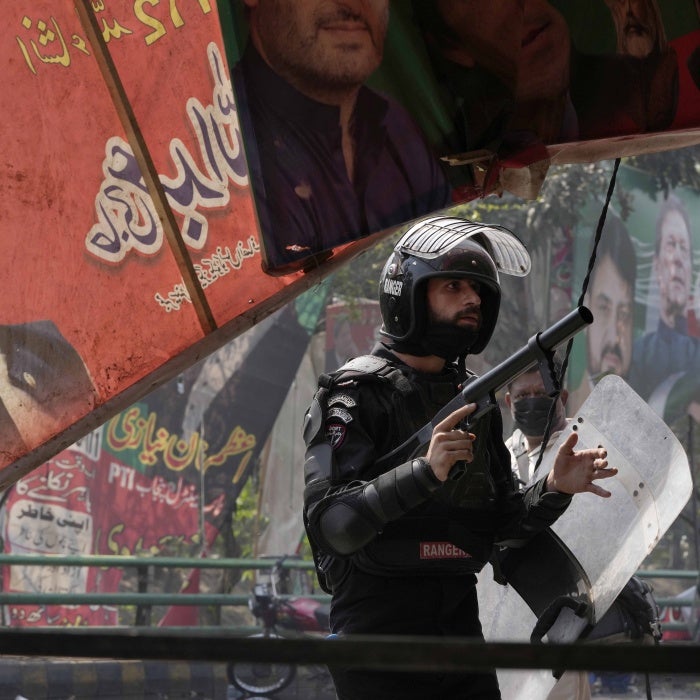 A riot police officer looks on after firing tear gas to disperse supporters of former Prime Minister Imran Khan during clashes in Lahore, Pakistan, March 15, 2023.