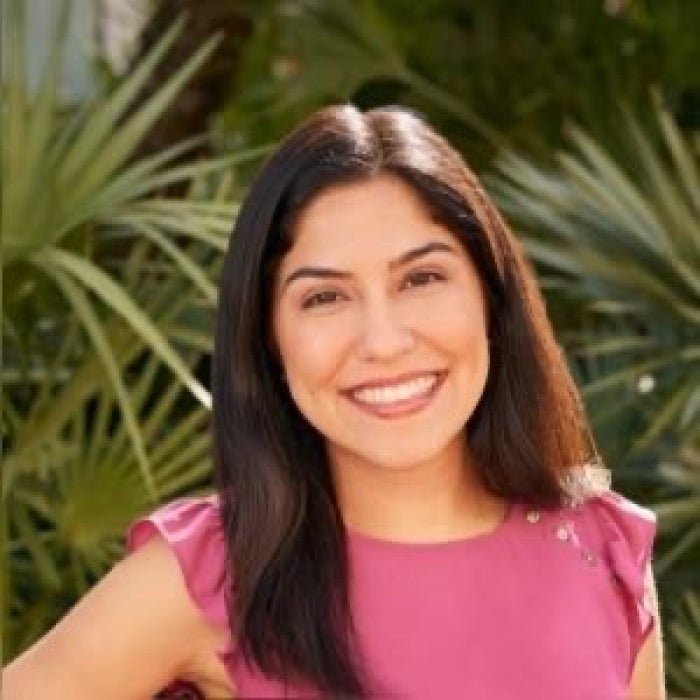 A photo of a woman with long brown hair smiling.  