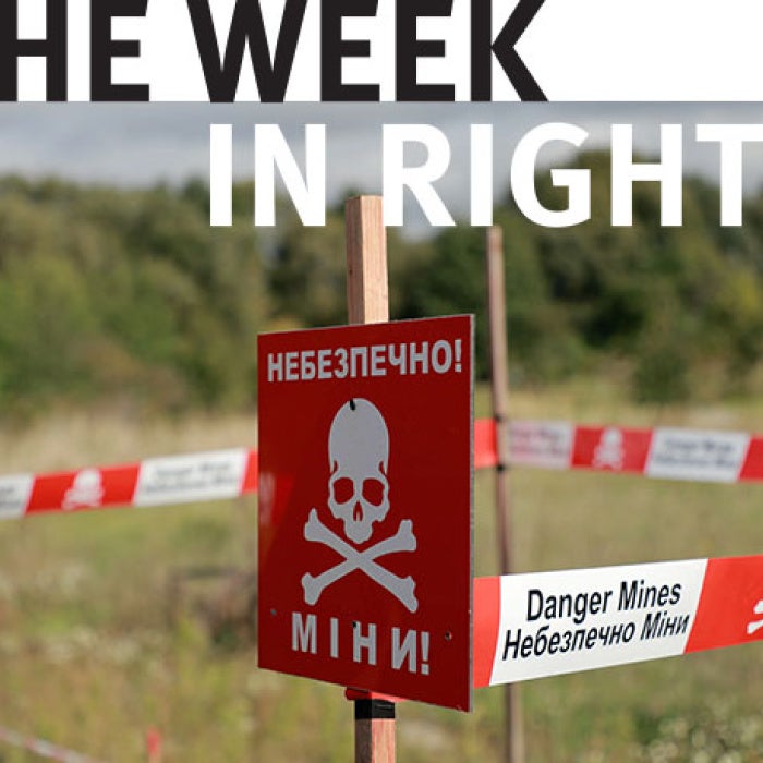 Landmine warning signs stand in field. 