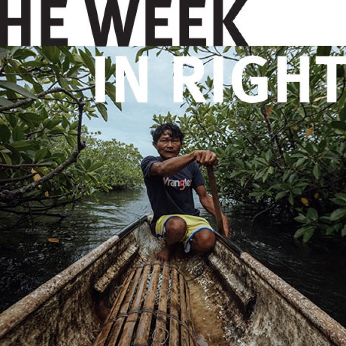 One figure navigates boat through river. 