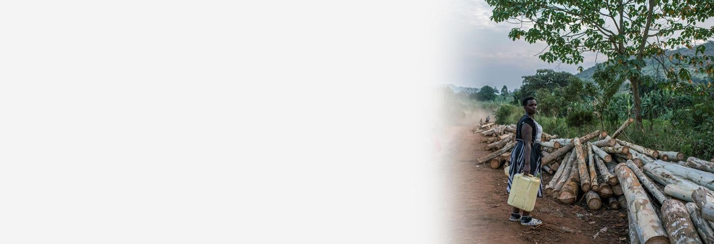 Cette femme rentrait du travail à Kijumba, en Ouganda, le 14 janvier 2023. Mère de cinq enfants, elle a vendu son terrain à une compagnie pétrolière pour un projet d’oléoduc. Mais elle a déclaré au New York Times qu'elle a attendu des années pour recevoir le paiement, et que finalement c'était trop peu pour acheter un terrain de remplacement.